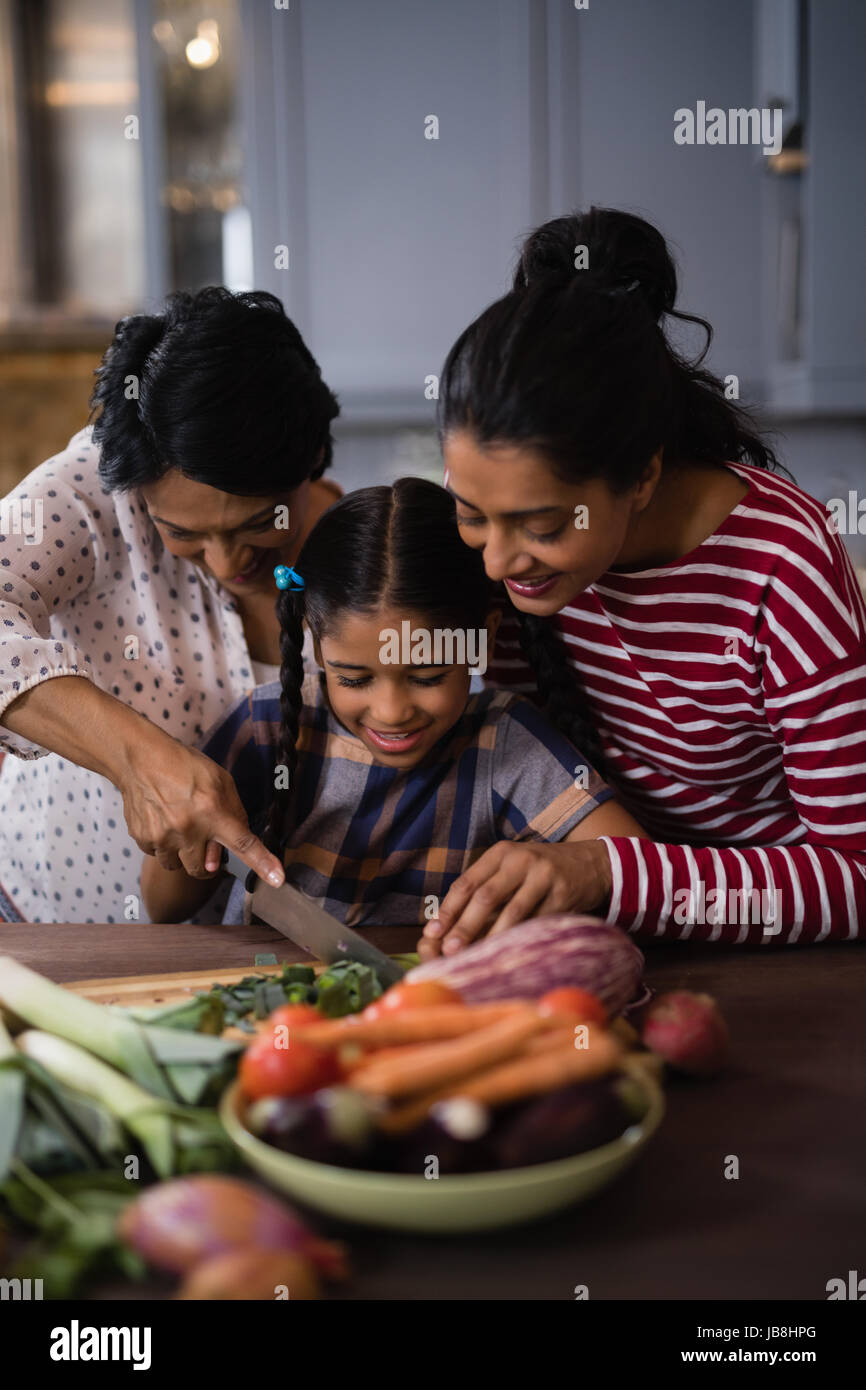 Sorridente multi-famiglia di generazione di preparare il cibo insieme nella cucina di casa Foto Stock