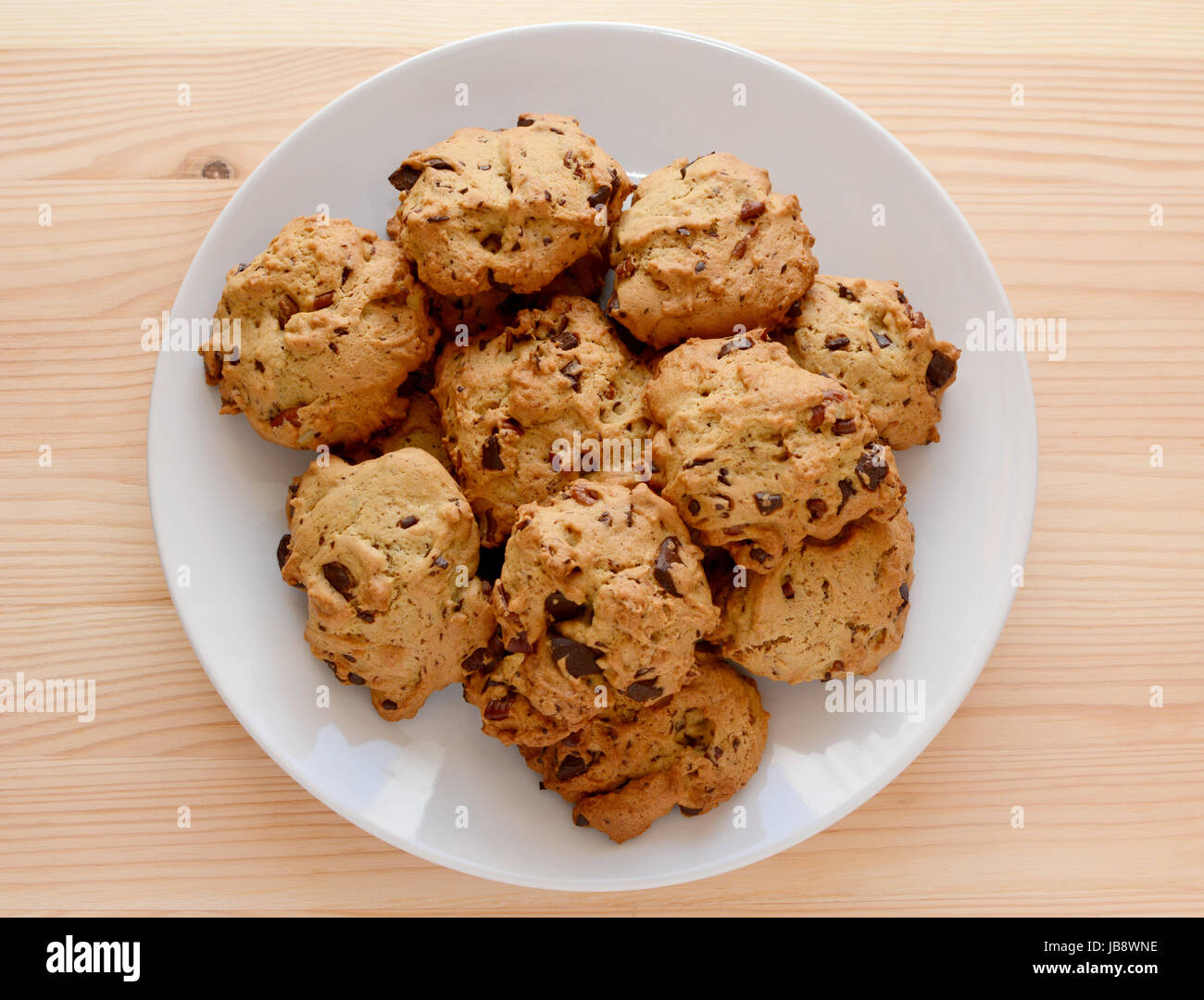 Piastra del pecan e biscotti al cioccolato dolce da forno su una tavola di legno Foto Stock