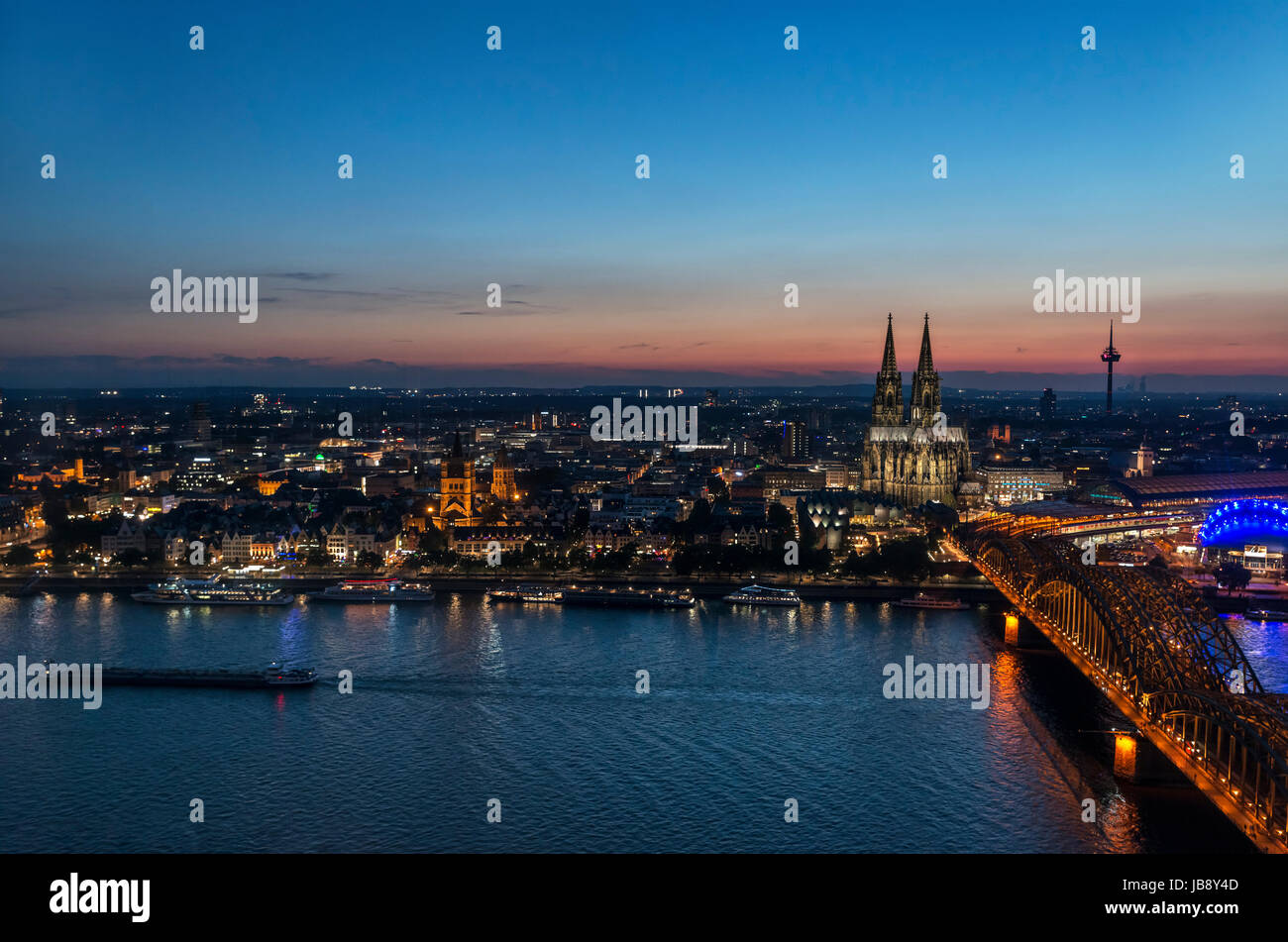 Il fiume Reno al tramonto, guardando verso la cattedrale di Colonia e la Città Vecchia con il ponte di Hohenzollern (Hohenzollernbrücke) in primo piano, Colonia, Germania Foto Stock