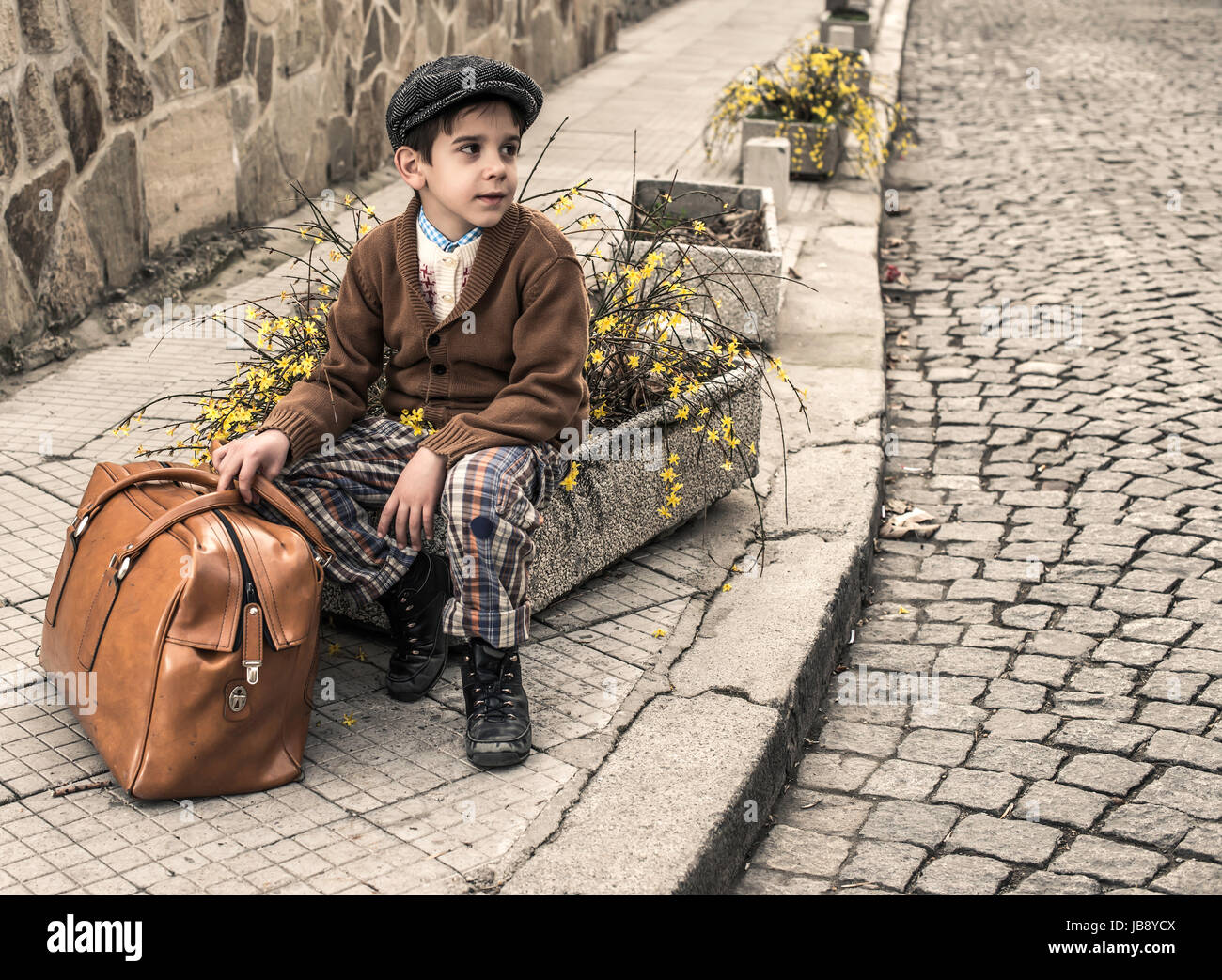 Bambino su una strada con borsa vintage. Abbigliamento Vintage style Foto  stock - Alamy