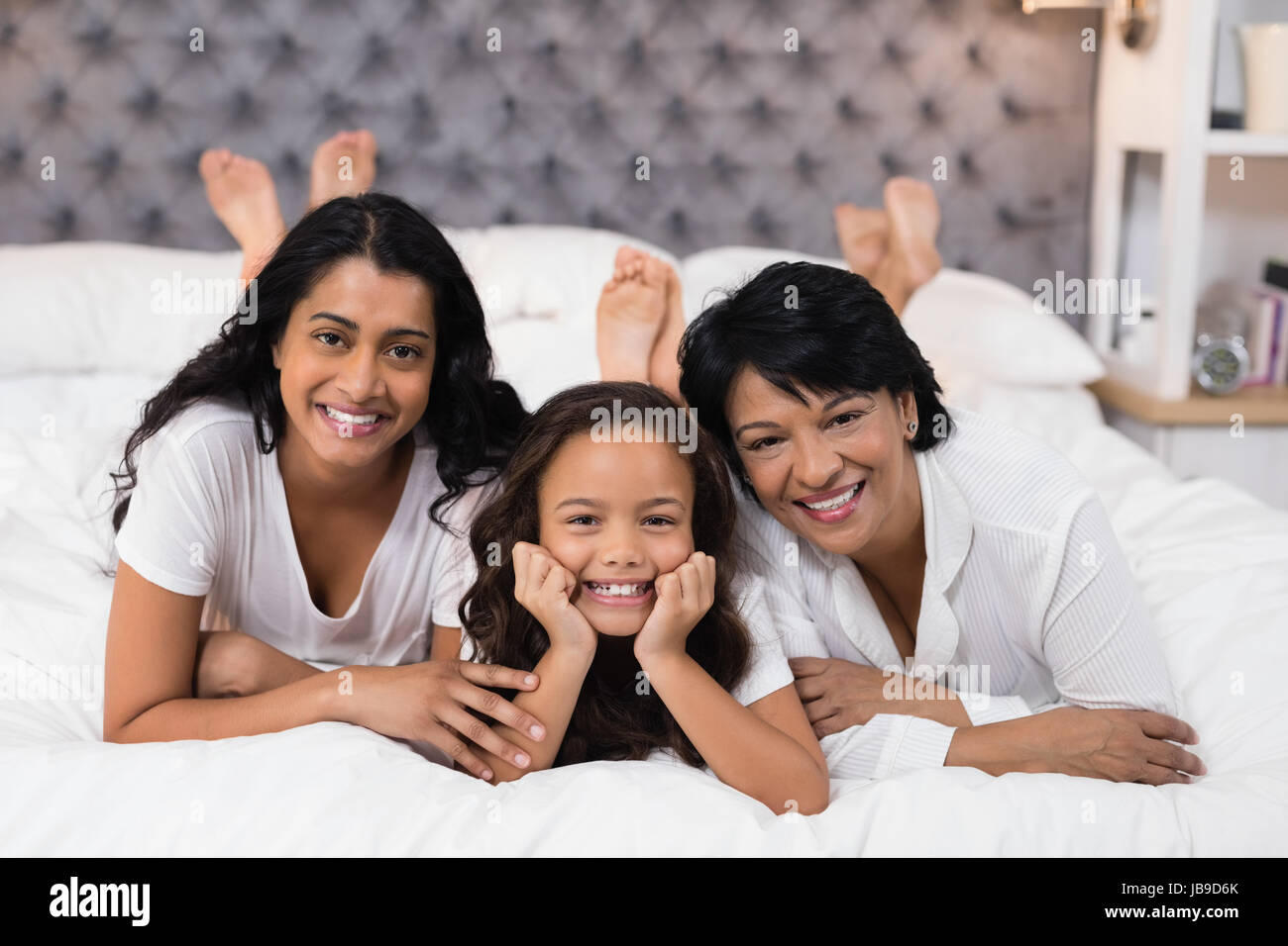 Ritratto di Allegro multi-generazione famiglia giacente sul letto di casa Foto Stock