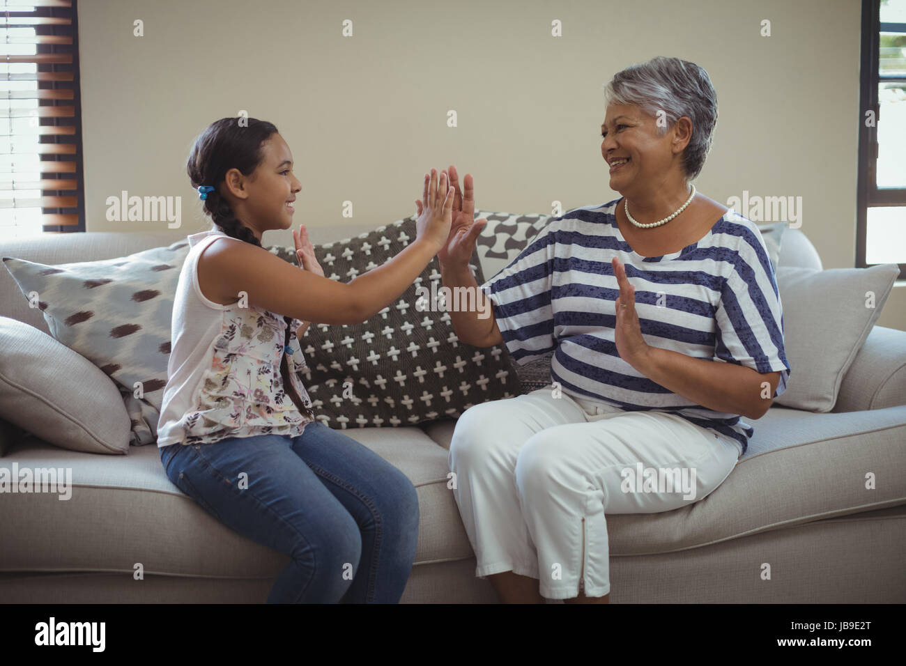 Nonna e nipote divertendosi nel salotto di casa Foto Stock