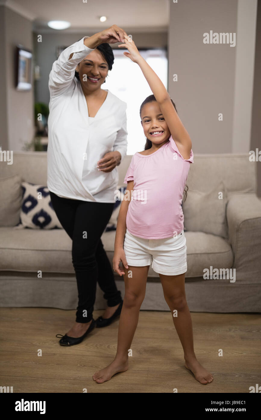 Ritratto di ragazza sorridente ballando con la nonna a casa Foto Stock