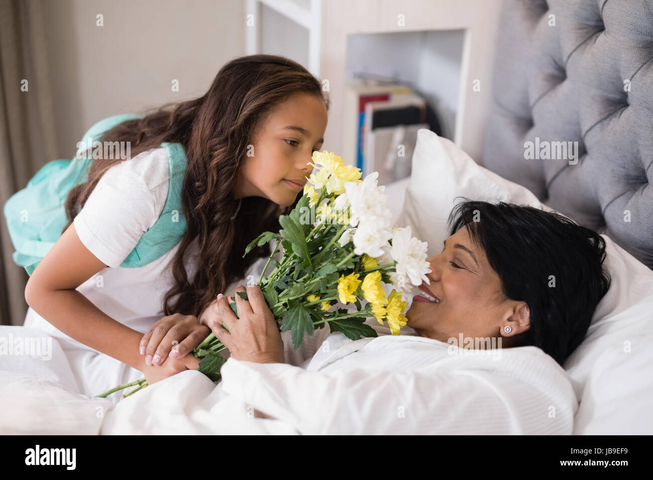 Elevato angolo visualizza ragazza bouquet dando ai malati la nonna a casa Foto Stock