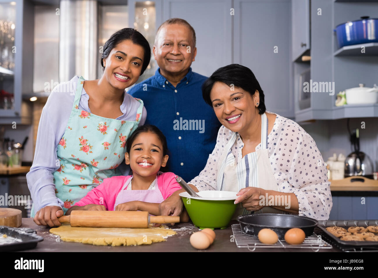 Ritratto di multi-famiglia di generazione in piedi insieme nella cucina di casa Foto Stock