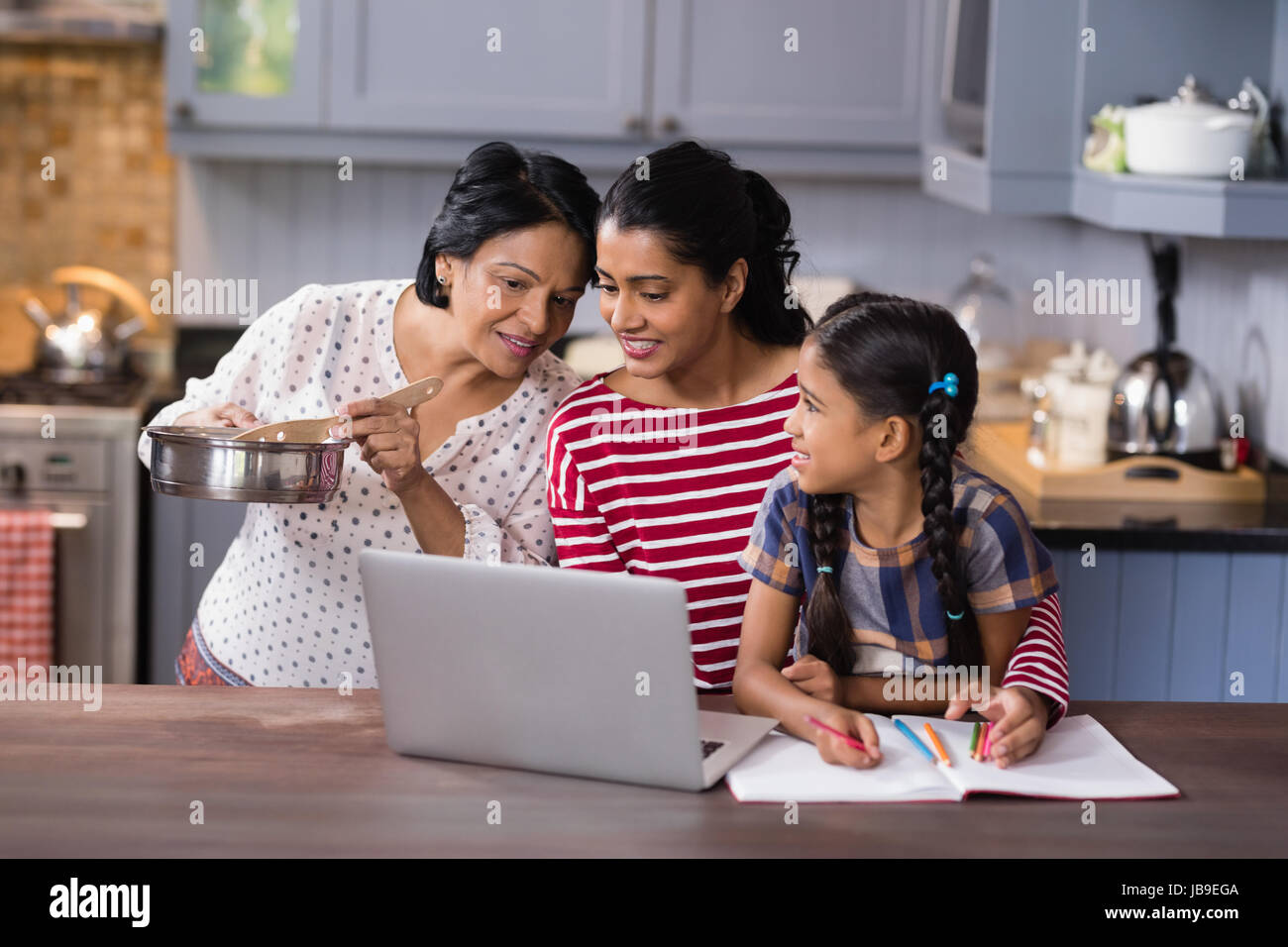 Multi-generazione famiglia utilizzando laptop in cucina a casa Foto Stock