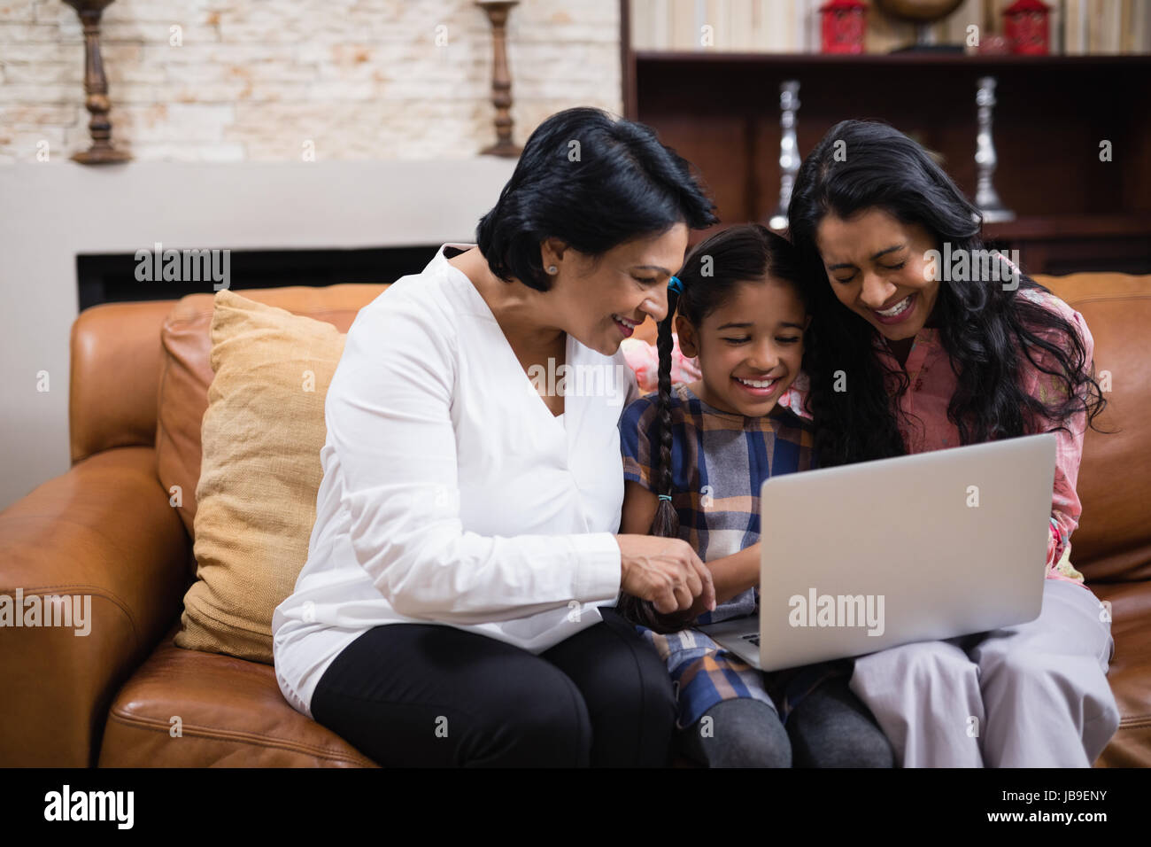 Felice multi-generazione famiglia utilizzando laptop insieme comodamente seduti sul divano di casa Foto Stock