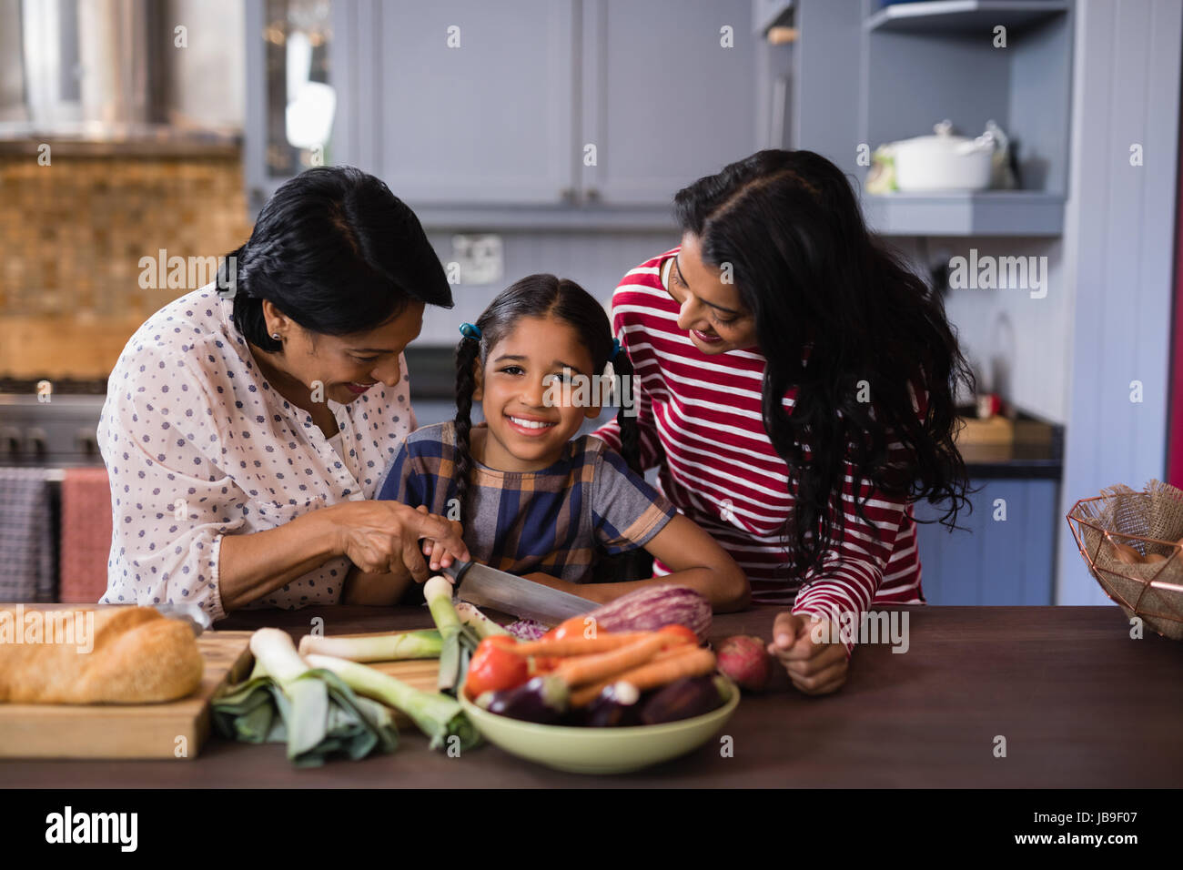 Ritratto di ragazza la preparazione di alimenti con la madre e la nonna in cucina a casa Foto Stock