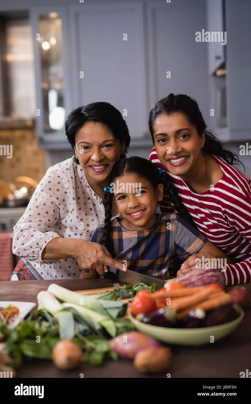 Ritratto di sorridere multi-famiglia di generazione di preparare il cibo insieme nella cucina di casa Foto Stock