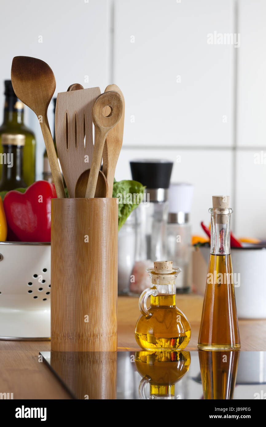 Kochlöffel und Ölflaschen am Kochfeld in Küche Foto Stock
