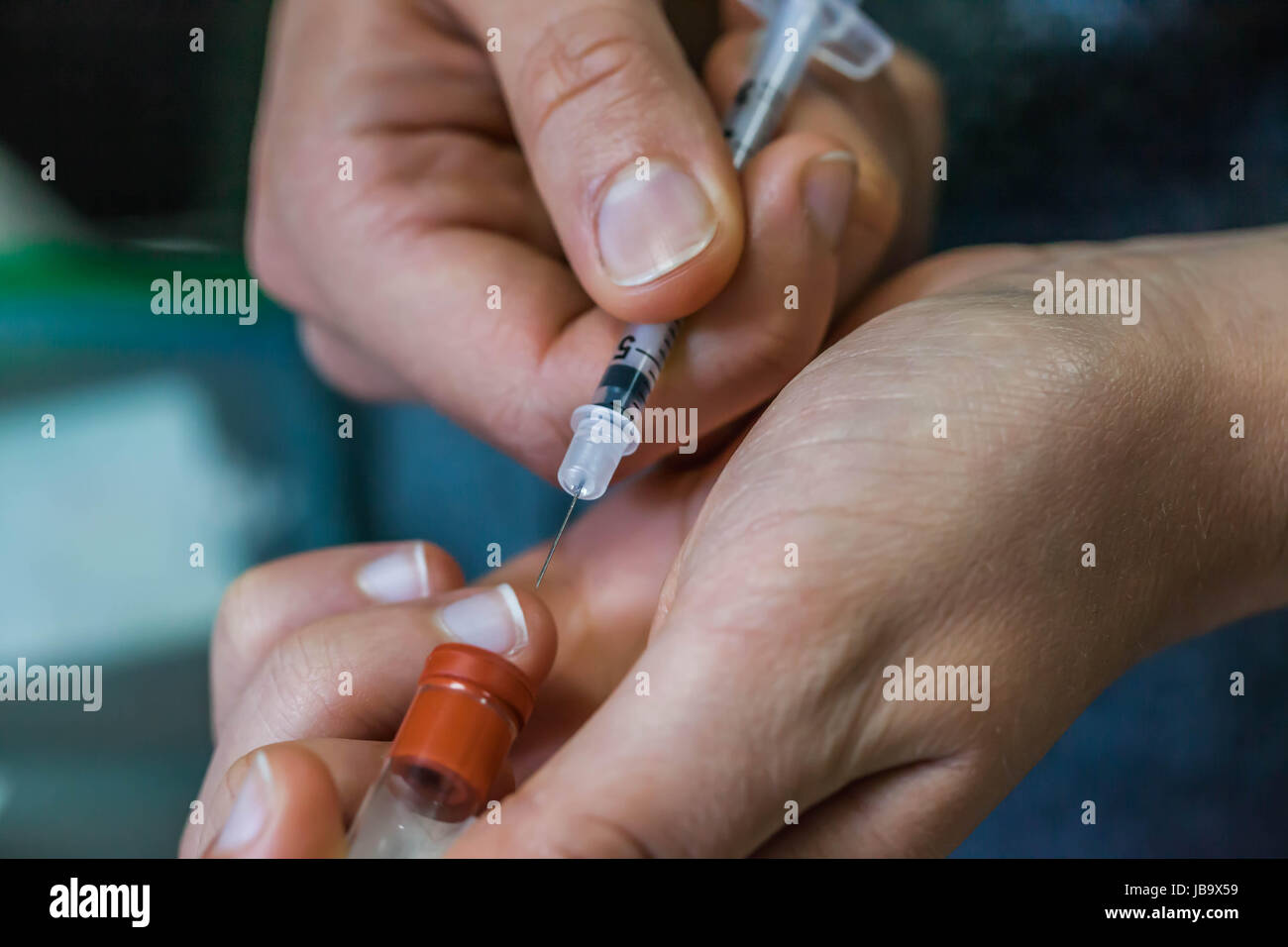 Infermiere trae medicina con ago e siringa Foto Stock