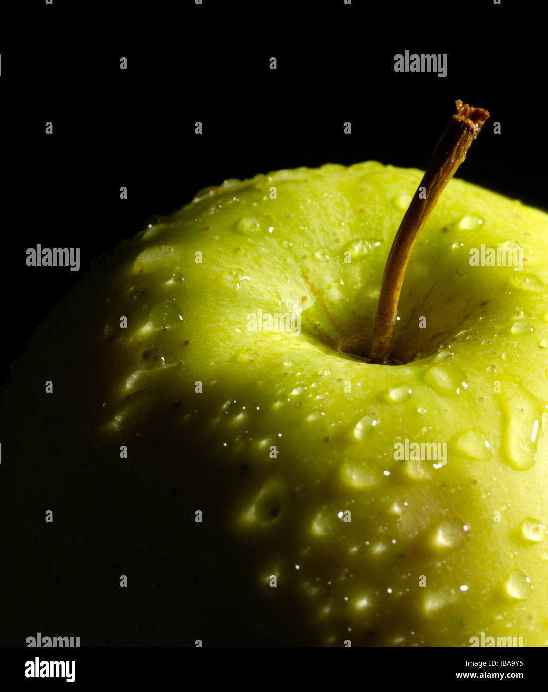 Dettaglio di un verde bagnato apple nel buio indietro Foto Stock