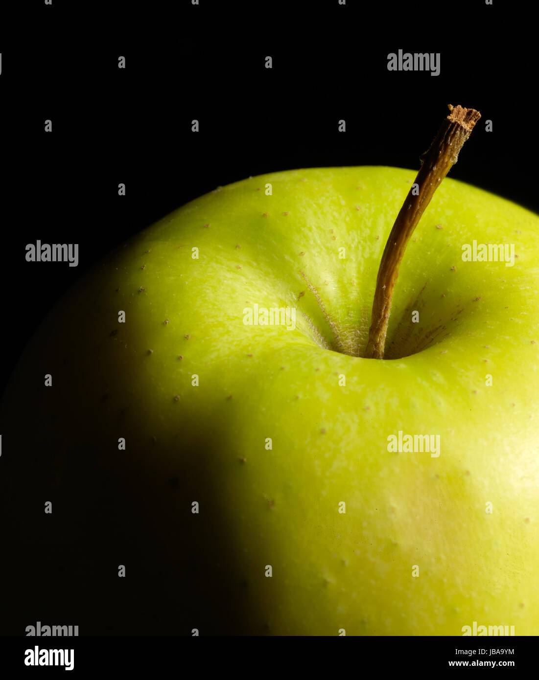 Dettaglio di una mela verde in dark indietro Foto Stock