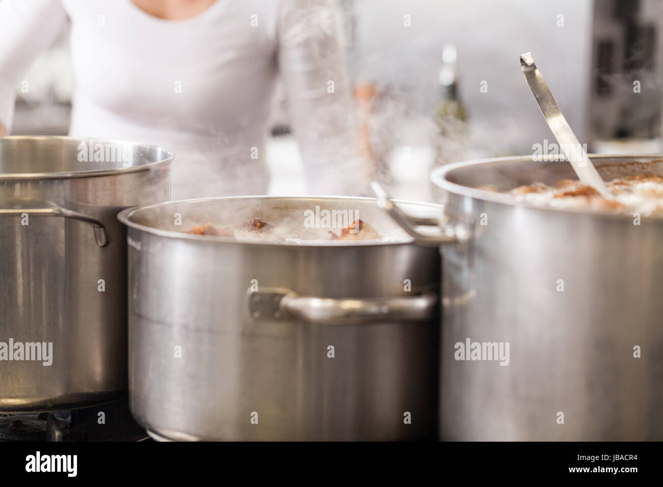 Gastronomie ristorante küche mit kochfeld und dampfenden töpfen beim kochen essen zubereiten cena Foto Stock