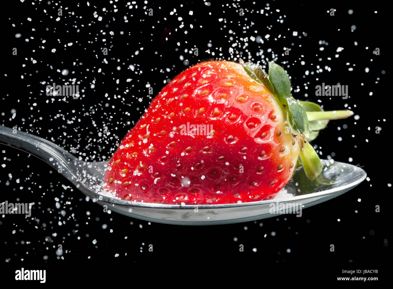 Fragola su un cucchiaio di zucchero versando su di esso, congelati con fotografie ad alta velocità Foto Stock
