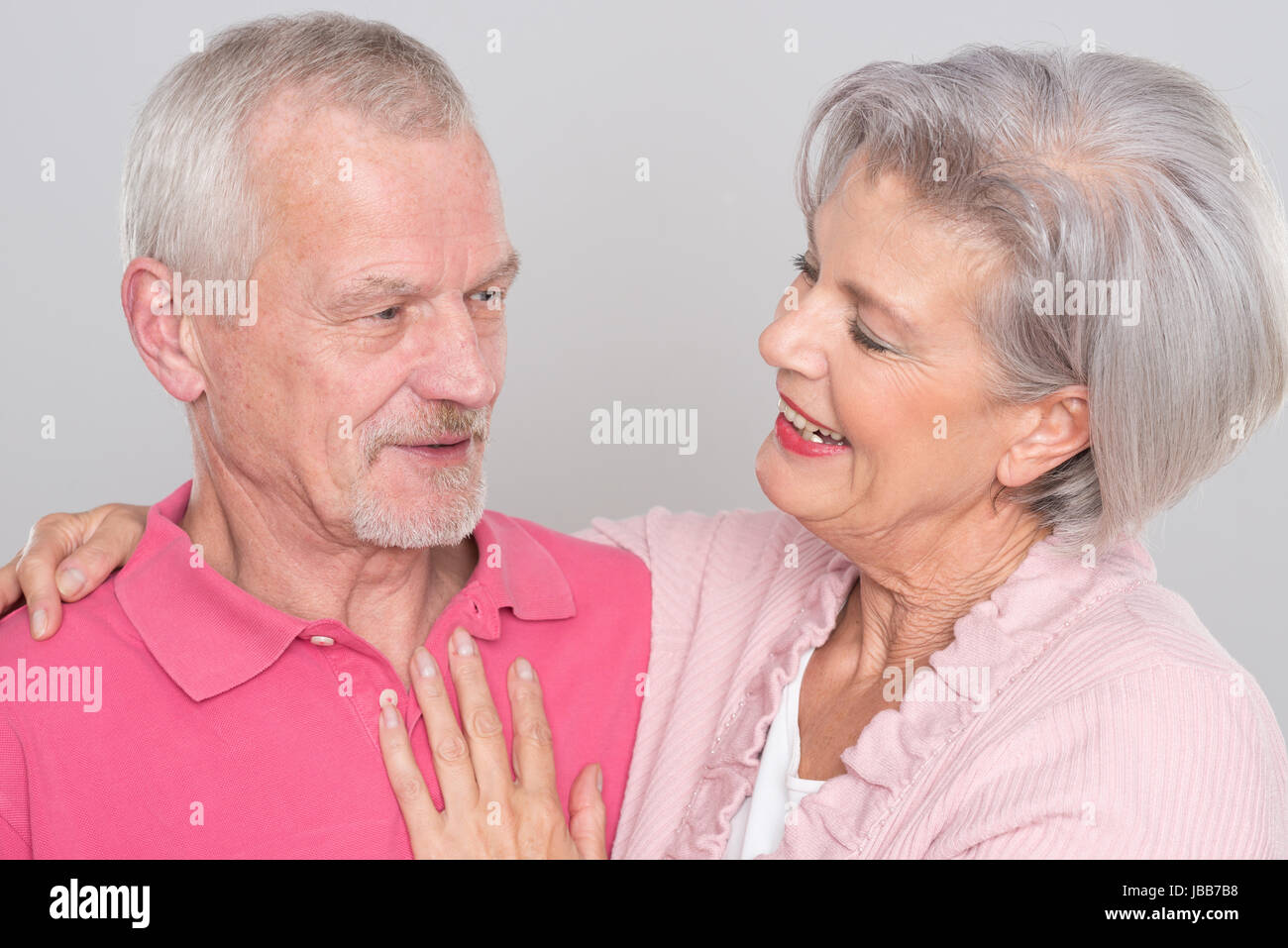 Glückliches Seniorenpaar vor grauem Hintergrund Foto Stock