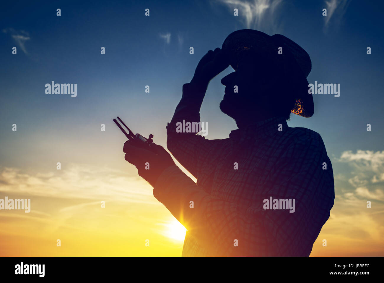 Silhouette di agricoltore utilizzando drone telecomando, smart farming attività agricola e il futuro dell'agricoltura Foto Stock