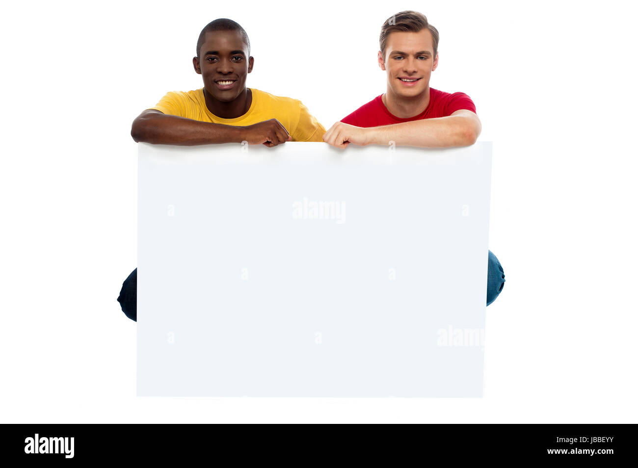 Casual giovani ragazzi in posa con billboard vuota isolata contro uno sfondo bianco Foto Stock
