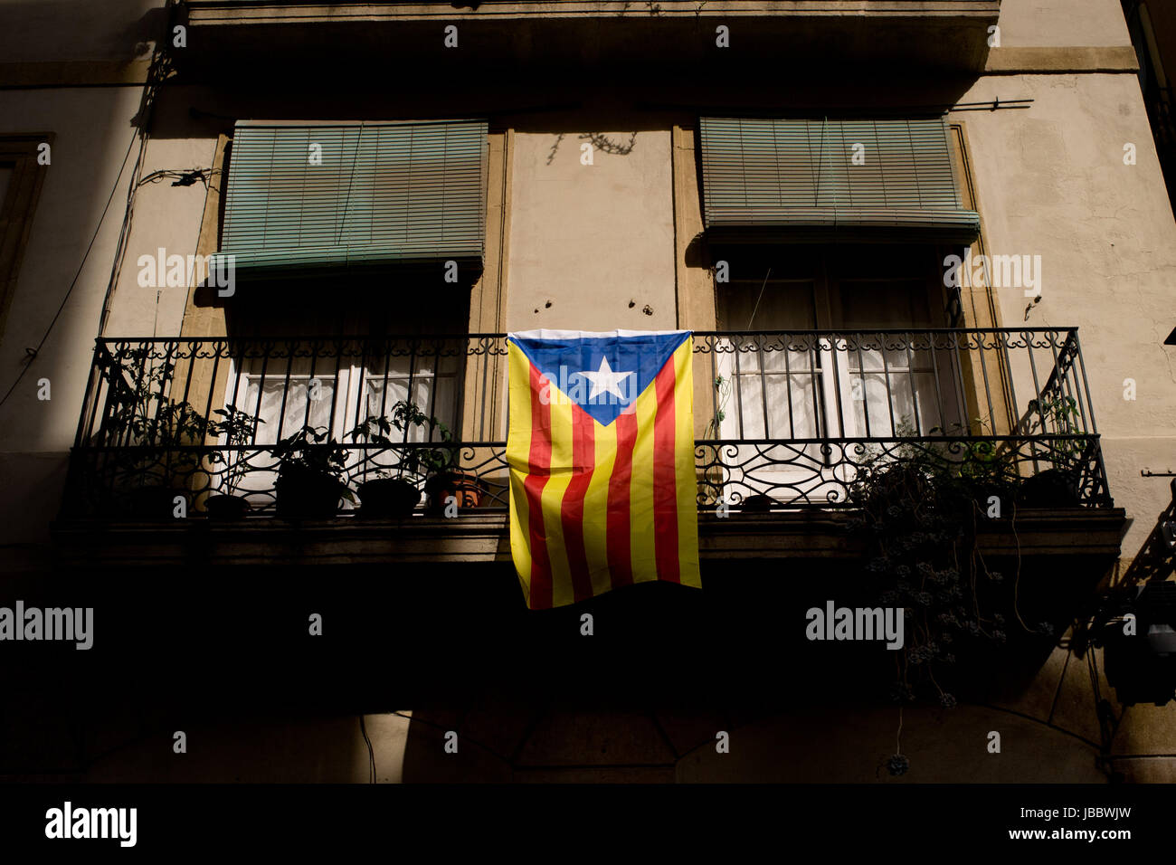 Una bandiera estelada (simbolo dell'indipendenza catalana) pende da un balcone a Barcellona, in Catalogna, Spagna. Foto Stock