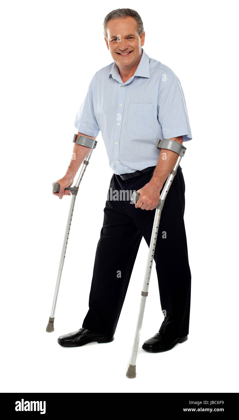 Senior man standing con l aiuto di stampelle. Ripristino da un incidente Foto Stock