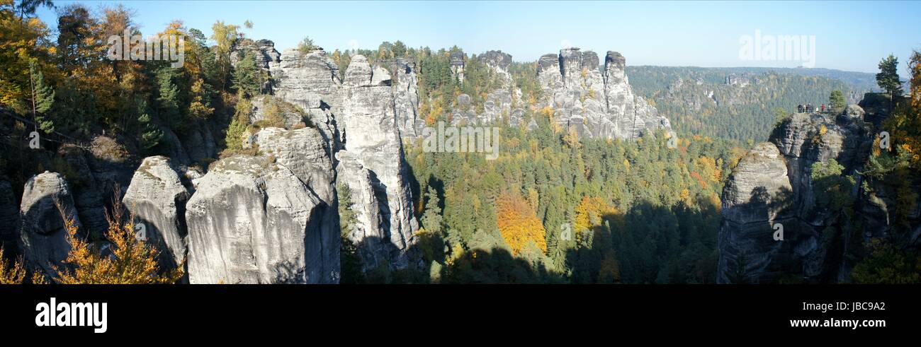 Blick von der Bastei auf die bizarren Felsen der Sächsischen Schweiz in Deutschland; bunte Herbstwälder und blauer Himmel vista dal Bastei sulla bizzarra rocce della Svizzera sassone in Germania; colori d'autunno foreste e cielo blu Foto Stock