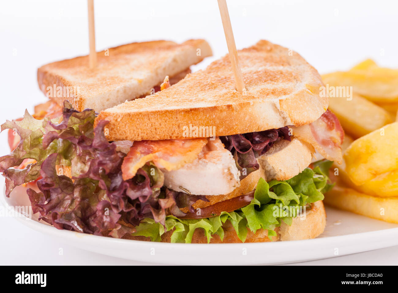Clubsandwich auf getoastetem Weißbrot mit Speck und Pommes frittes Fritten auf einem Teller isoliert vor weißem Hintergrund Foto Stock