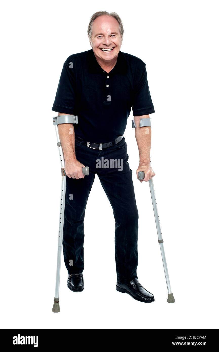 Anziani vittima di incidente il recupero in modo piuttosto notevole. A piedi con aiuto di stampelle. Foto Stock