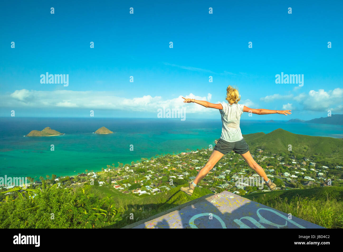 Scatola di pillole Lanikai escursione. Hawaiian escursionismo godendo. Gioiosa carefree escursionista jumping. Donna felice celebra uno dei più spettacolare di Oahu sentieri escursionistici in ha Foto Stock