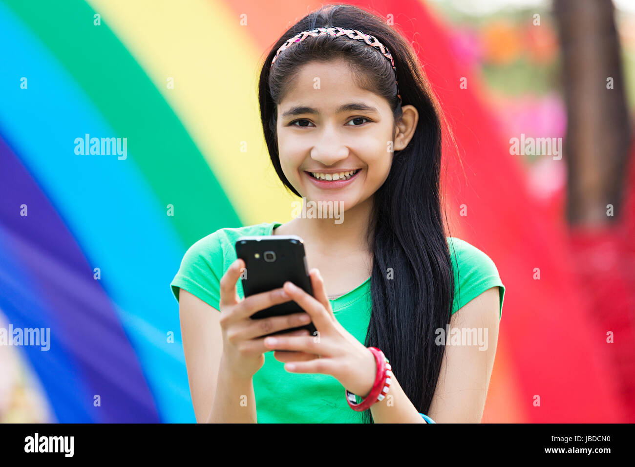 1 Giovane ragazza adolescente di invio di messaggi di testo telefono godere di mela Foto Stock