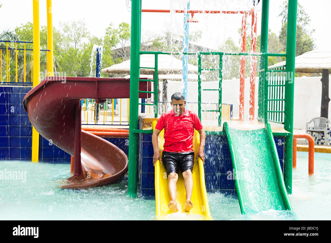 1 senior indiano uomo ride di balneazione parco acquatico di scorrimento Foto Stock