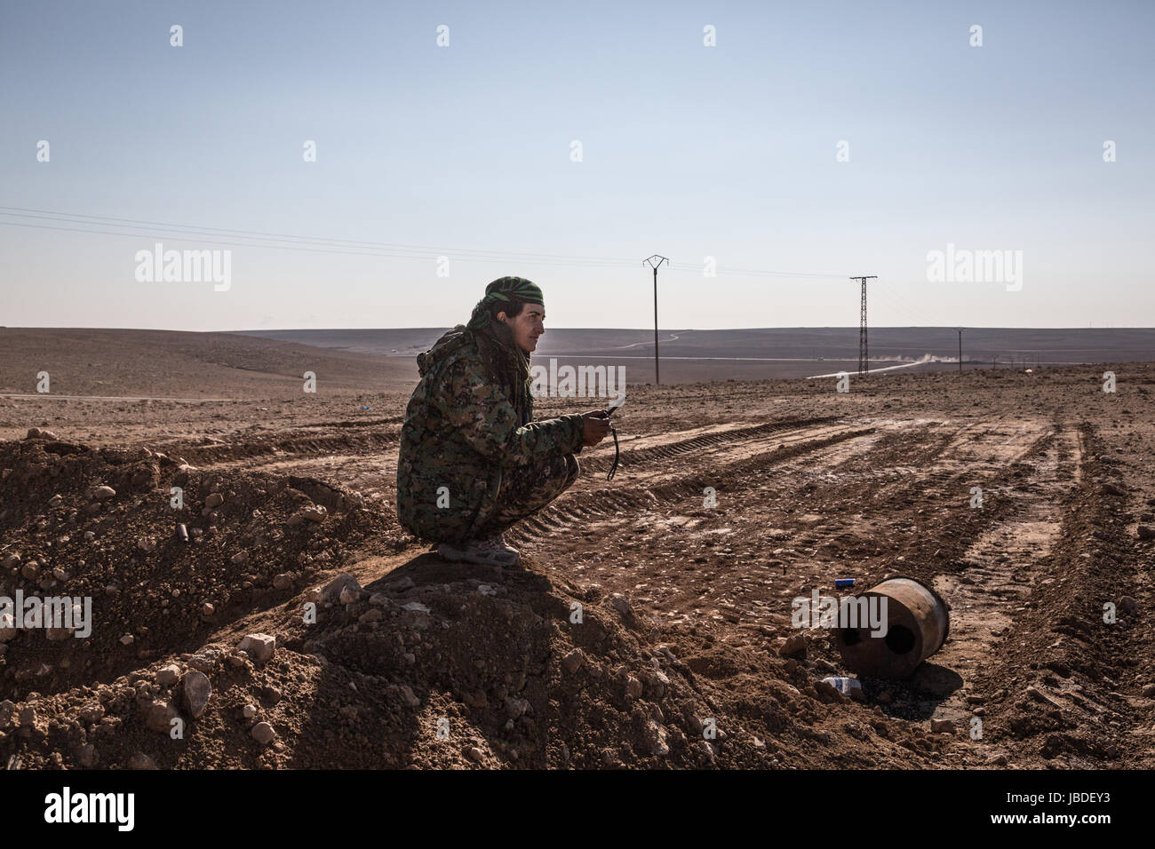 Chris huby / le pictorium - Siria / rojava - ira dell'Eufrate - 19/12/2016 - rojava - Siria - rojava - Dic16 e Jan17 - una giovane donna da ypj osserva a distanza e ascolta i comandi del suo comandante a sinistra alla base. Foto Stock