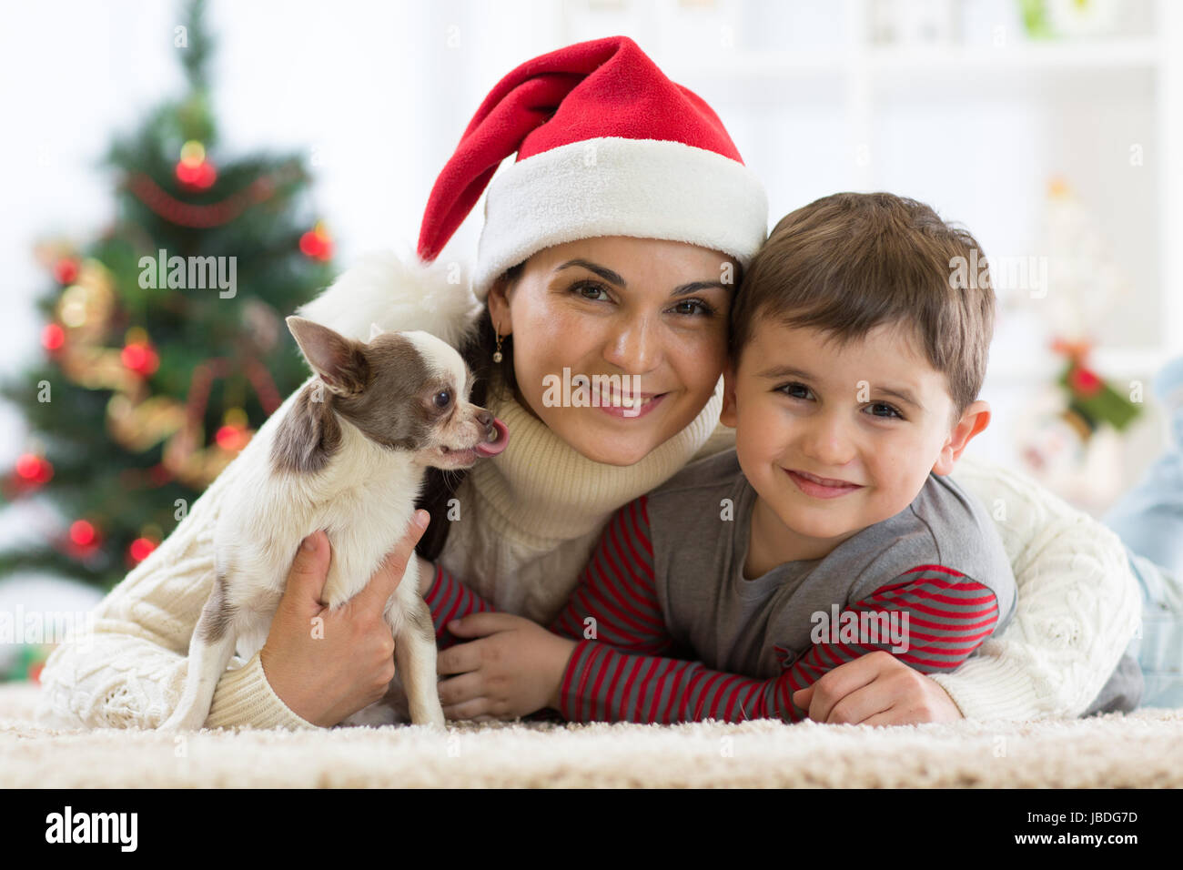 Ritratto di una famiglia felice e il cane trascorrere insieme il tempo di Natale a casa vicino al X-mas tree Foto Stock