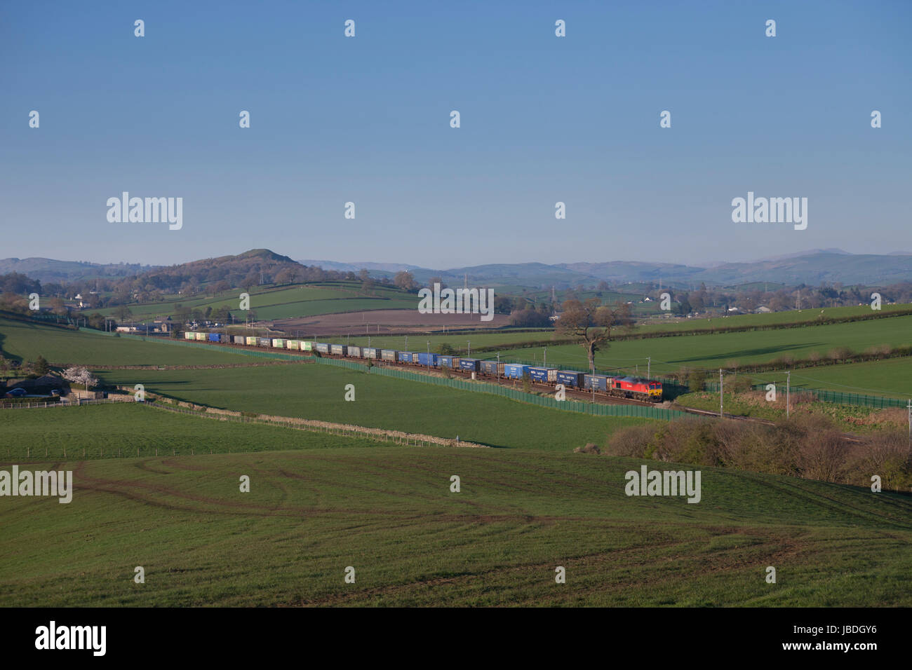 DB Cargo Classe 66 motrice passa teste pozzo (Sud di Oxenholme, Cumbria Regno Unito) con un Grangemouth-Daventry contenitore intermodale treno merci Foto Stock