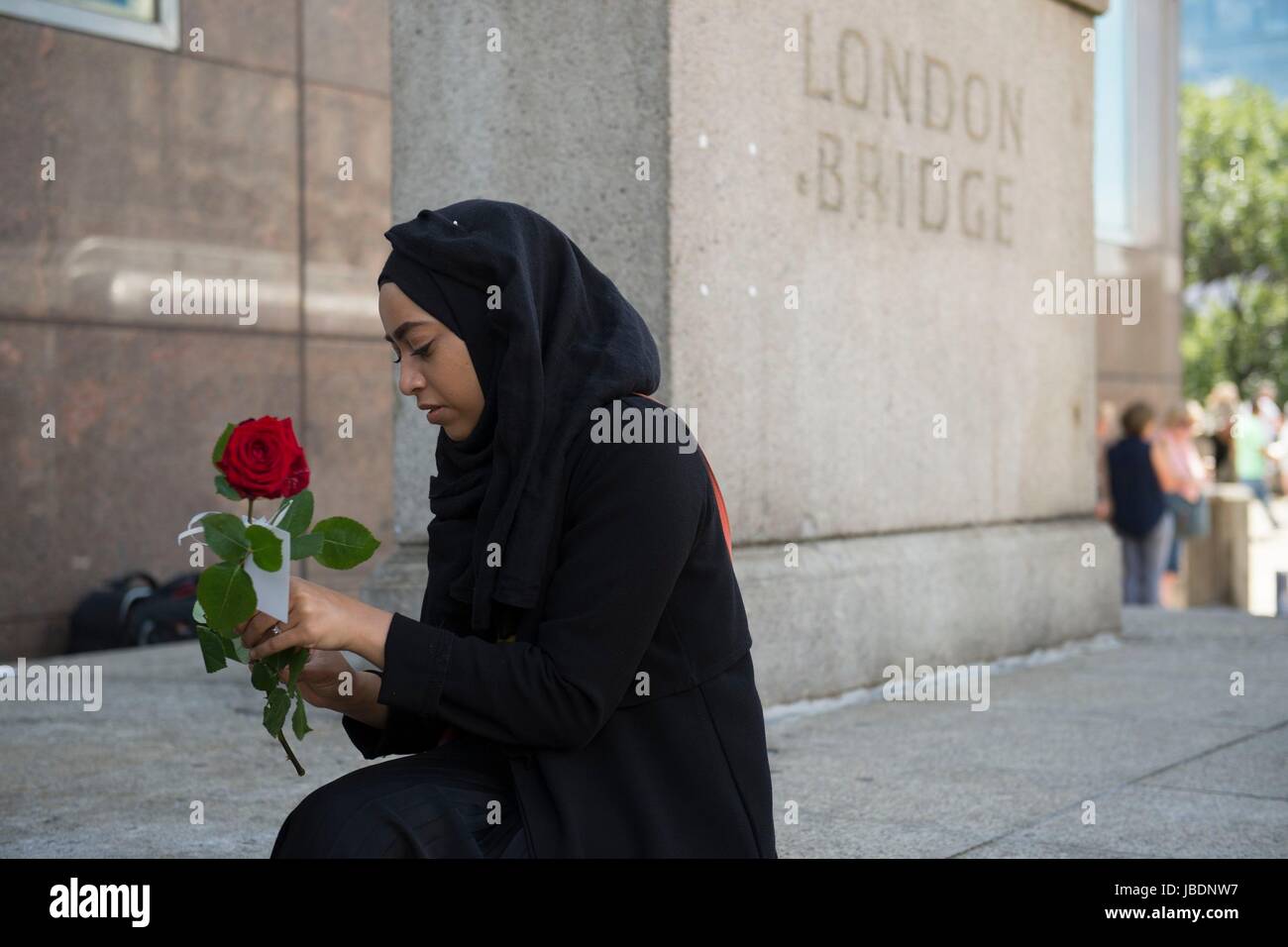 Una donna si prepara a dare fuori rose sul London Bridge con messaggi di 'amore e solidarietà', poco più di una settimana dopo dall'attacco terroristico sul ponte e al Borough Market. Foto Stock