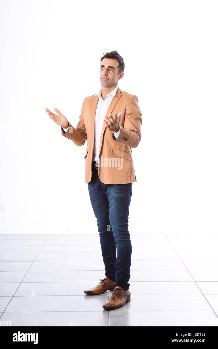 Un 35 - 40 anni uomo caucasico capelli scuri cool moderno look informale blazer, bracci mobili per spiegare lo sfondo bianco studio full shot Foto Stock