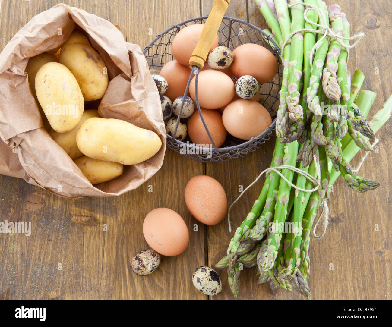 Frischer gruener Spargel , Bio-Kartoffeln und verschiedene rohe Eier Foto Stock