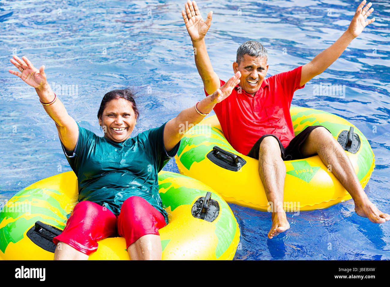 2 seniors indiano giovane parco acquatico anello gonfiabile divertimento flottante Foto Stock