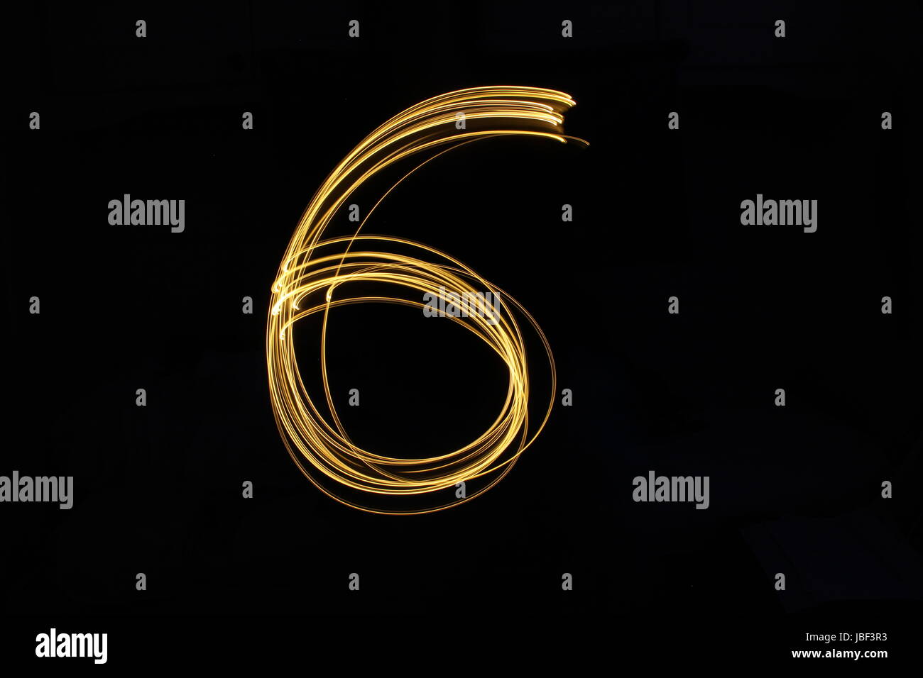 Numero Gold 6, luce fotografia pittura, numero serie, contro uno sfondo nero Foto Stock