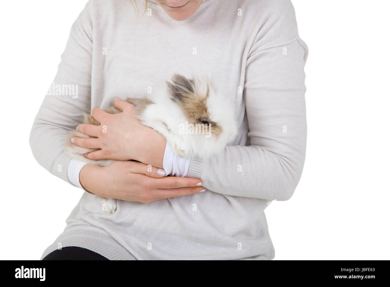 Coniglio Bianco con pelo lungo sul braccio di una donna Foto Stock