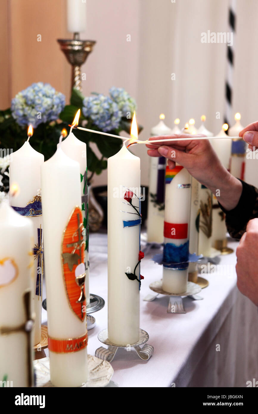 Colorate candele accese in chiesa Foto Stock