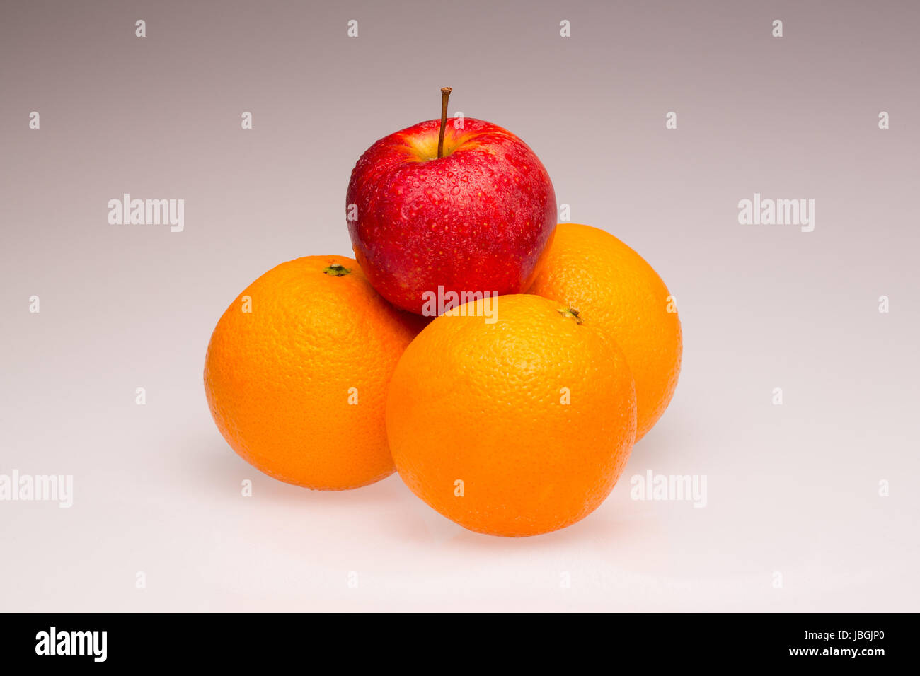 Orangen und ein roter Apfel als Symbol für Differenzierung und Unterscheidungsmerkmal Foto Stock