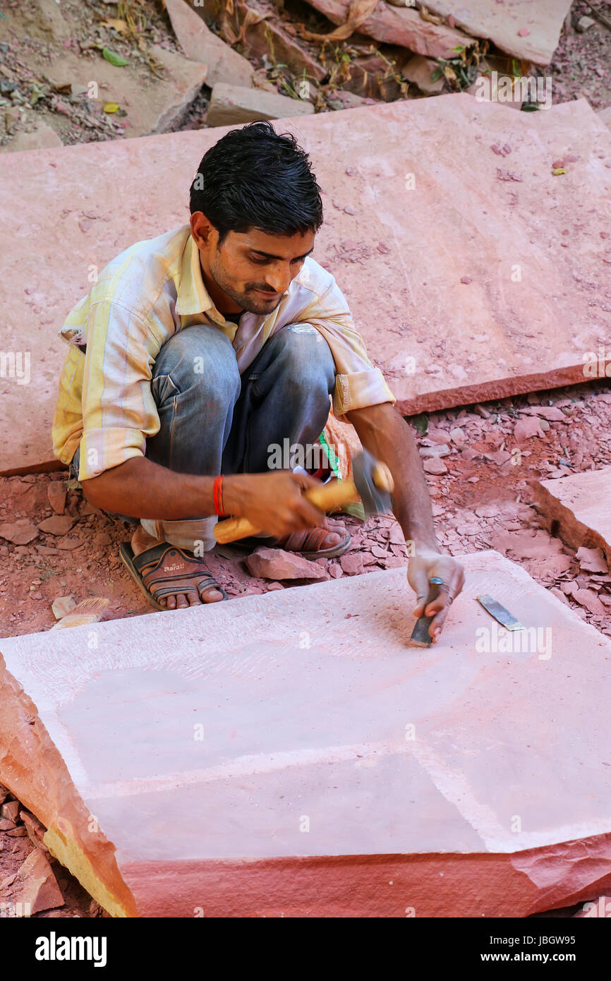 Uomo al lavoro su un pezzo di pietra arenaria al di fuori del Taj Mahal complesso in Agra, Uttar Pradesh, India. Agra è una delle più popolose città in Uttar Pradesh Foto Stock