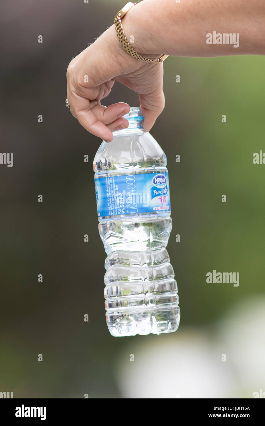 QUENINGTON, Regno Unito - 4 giugno 2017: la mano che regge una bottiglia di acqua da Nestlé Foto Stock