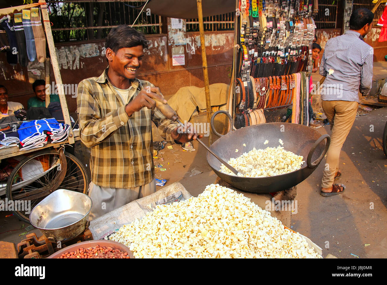 Giovane uomo popping popcorn a Kinari Bazar in Agra, Uttar Pradesh, India. Agra è una delle più popolose città in Uttar Pradesh Foto Stock