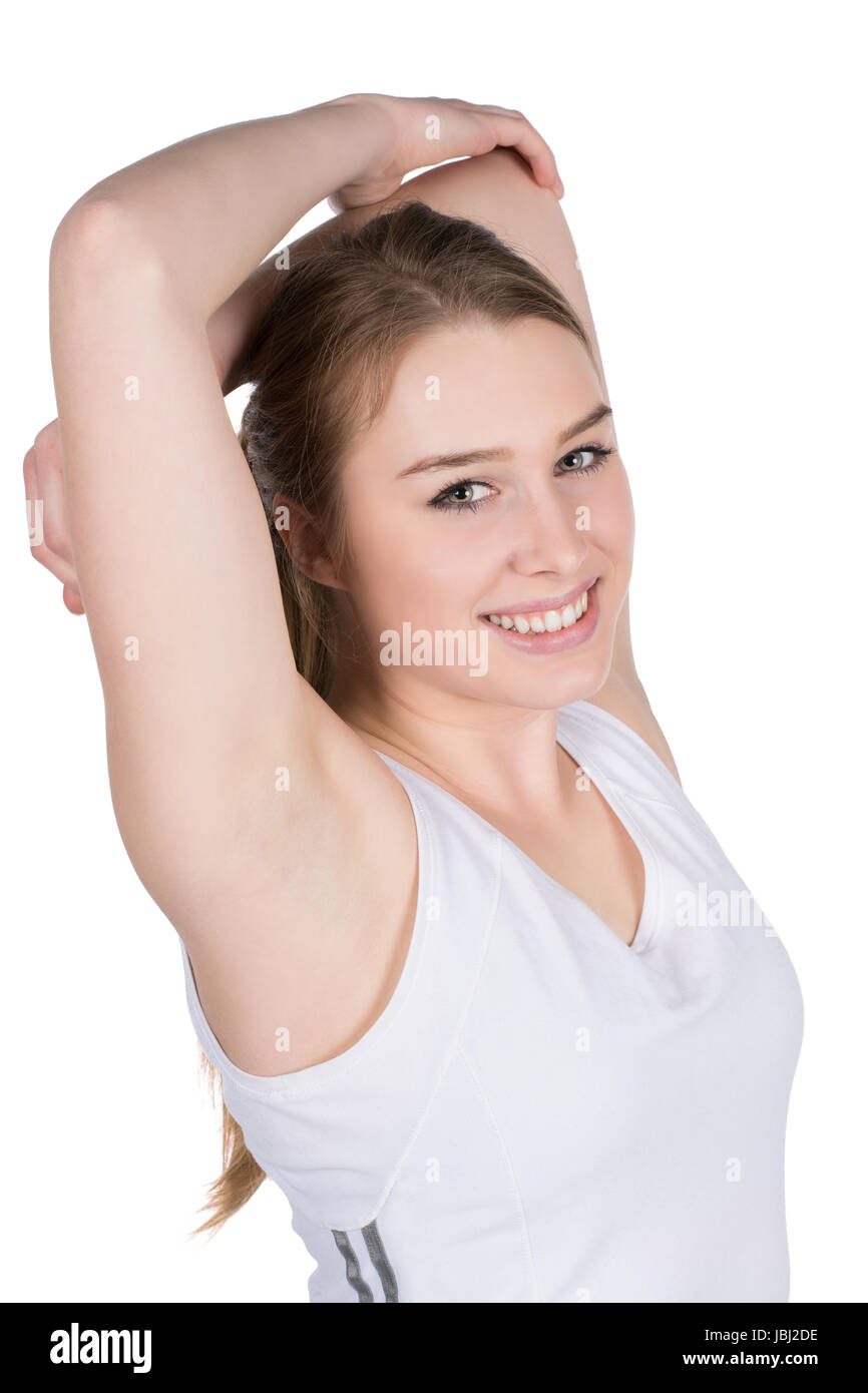 Freigestelltes Foto einer stehenden, jungen Frau, die ihre Armmuskulatur dehnt Foto Stock