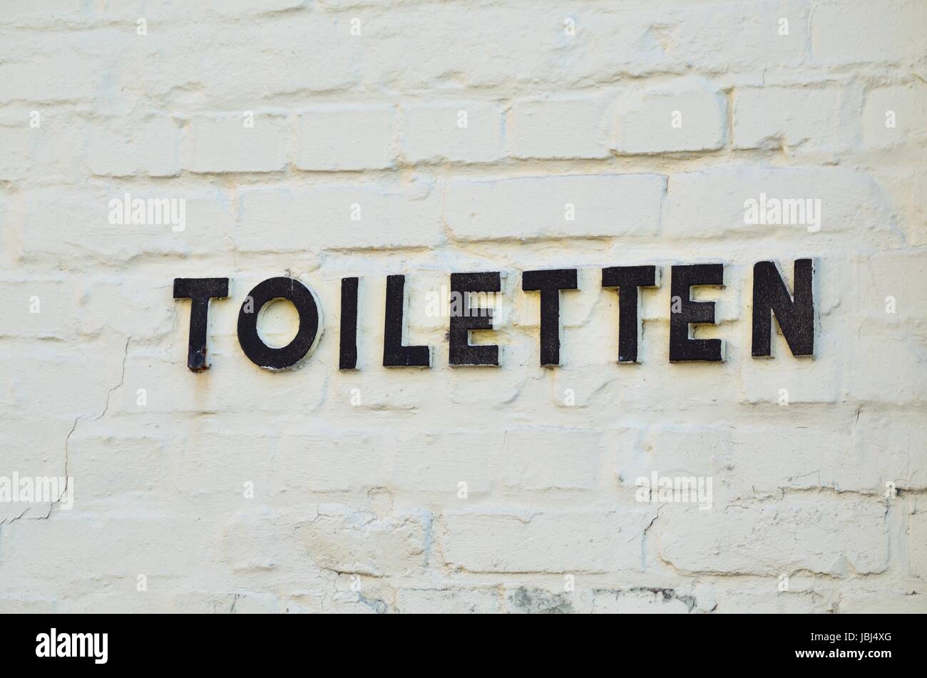 Buchstaben aus Metall weisen auf eine Toilette hin Foto Stock