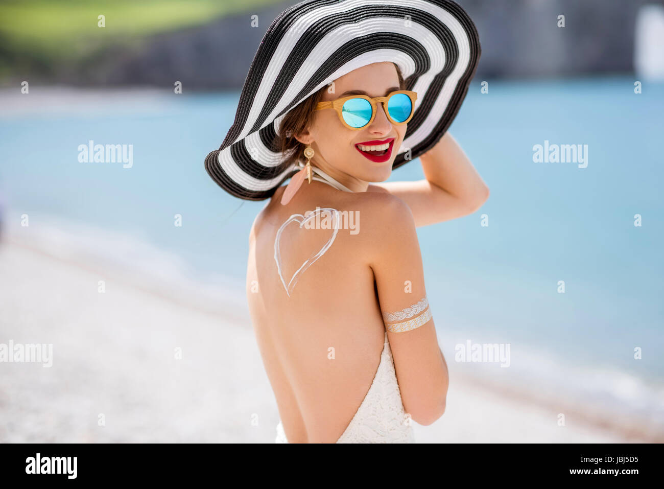 La donna a prendere il sole con crema di protezione solare Foto Stock