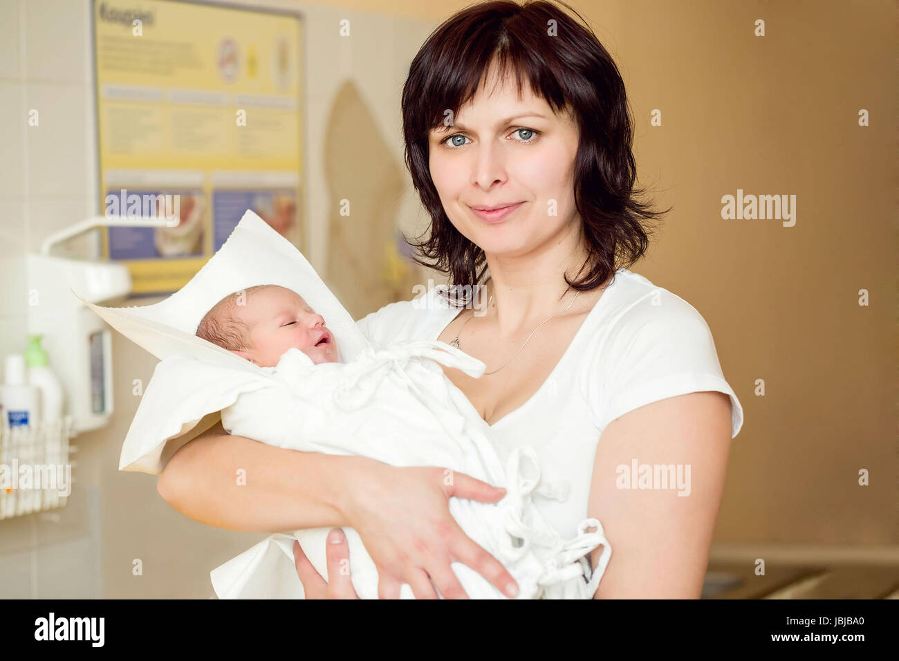 Madre con la sua incantevole piccola bambina in baby wrap in ospedale, le prime ore della nuova vita, della messa a fuoco per neonato Foto Stock