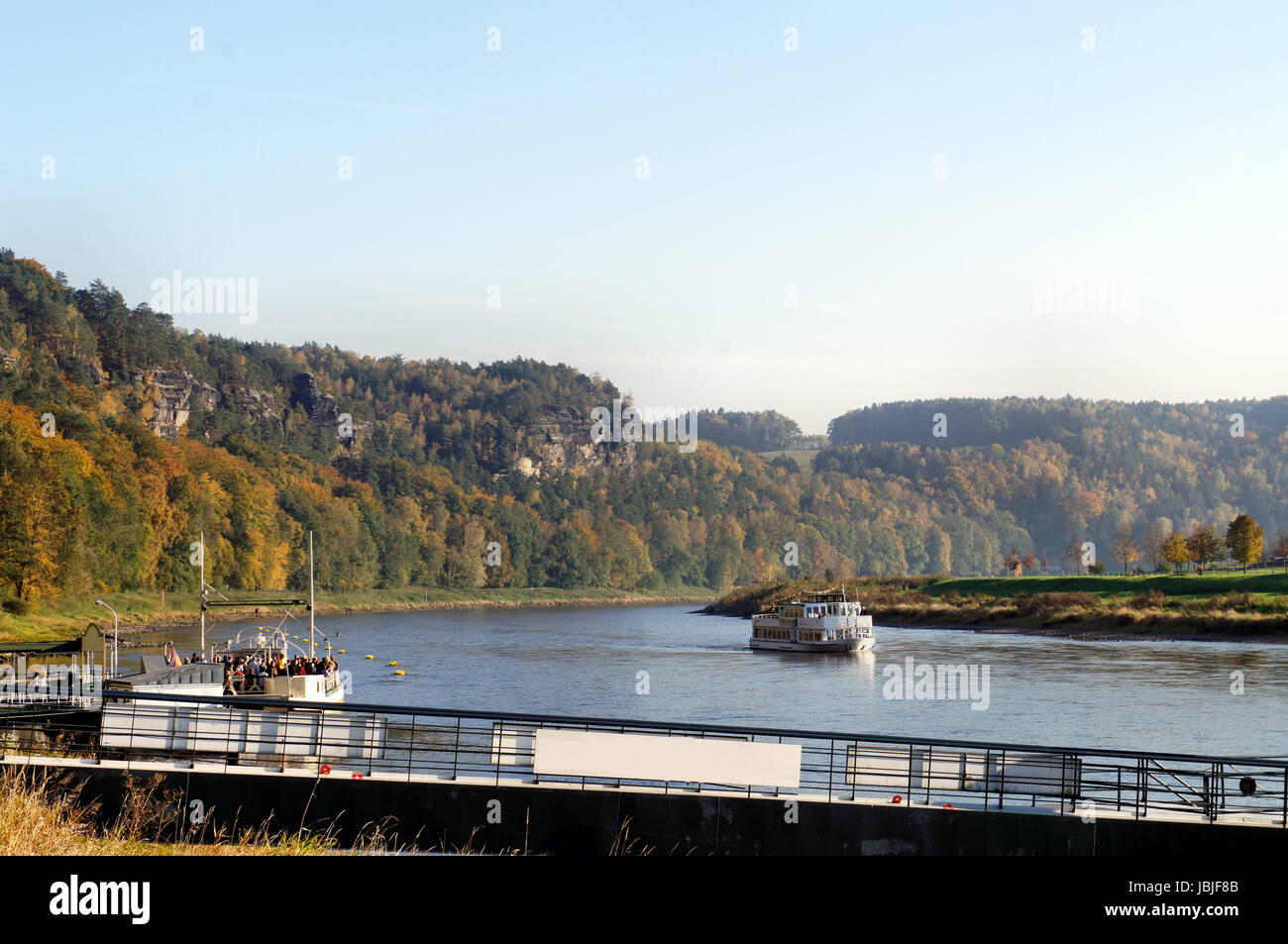 Die Elbe im deutschen Teil des Elbsandsteingebirges; steile Felsen und bunte Laubwälder; auf dem Fluss ein Dampfer und eine Fähre il fiume Elba nella parte tedesca dell'Elba montagne di arenaria; ripide rocce e coloratissimi boschi di latifoglie; sul fiume di un sistema di cottura a vapore e un traghetto Foto Stock