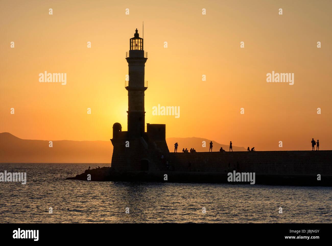 Chania, Creta silhouette al tramonto sopra il faro all'ingresso del porto veneziano parete di Hania, Creta, Grecia Foto Stock